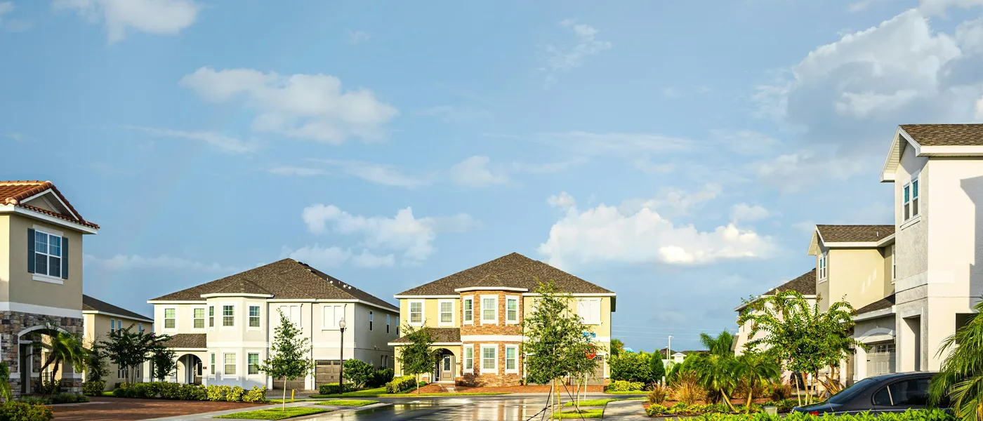 A residential street of Florida homes with palms and a wide sidewalk
